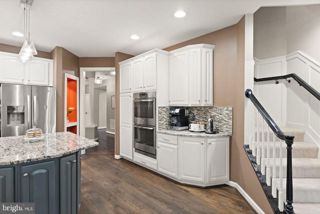 kitchen with pendant lighting, appliances with stainless steel finishes, and white cabinets