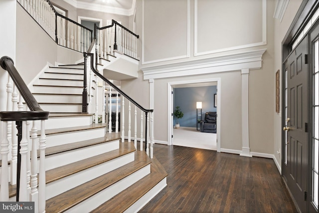 foyer entrance with crown molding, dark hardwood / wood-style flooring, and a high ceiling