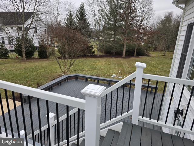 wooden terrace featuring a yard