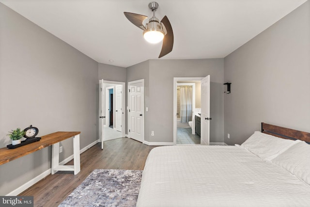 bedroom with dark wood-type flooring, ceiling fan, and connected bathroom