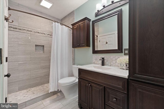 bathroom with tasteful backsplash, vanity, toilet, and a shower with shower curtain