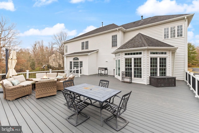 deck featuring an outdoor living space with a fire pit