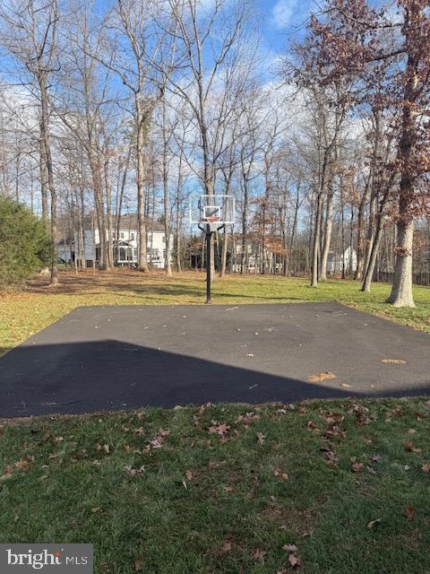 view of basketball court with a yard