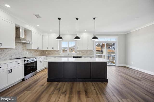 kitchen featuring a center island, light countertops, white cabinets, wall chimney range hood, and stainless steel electric range