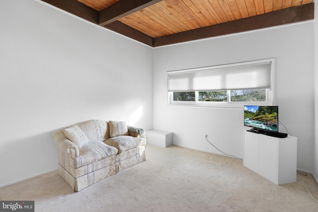 sitting room featuring beam ceiling, light colored carpet, and wood ceiling