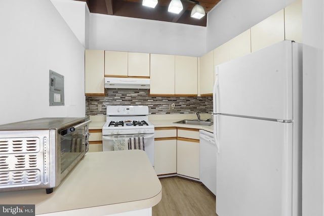 kitchen featuring tasteful backsplash, sink, white appliances, and exhaust hood