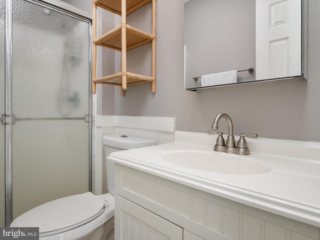 full bathroom with a shower with shower door, vanity, and toilet