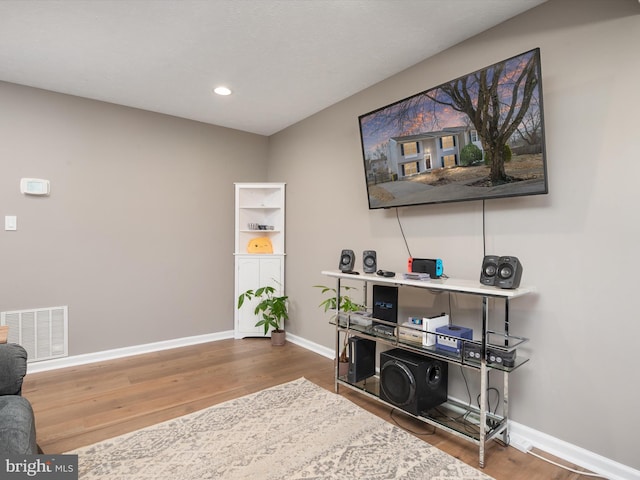 sitting room with visible vents, baseboards, and wood finished floors