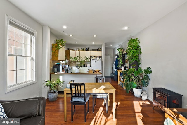 dining area featuring dark hardwood / wood-style floors and a wood stove