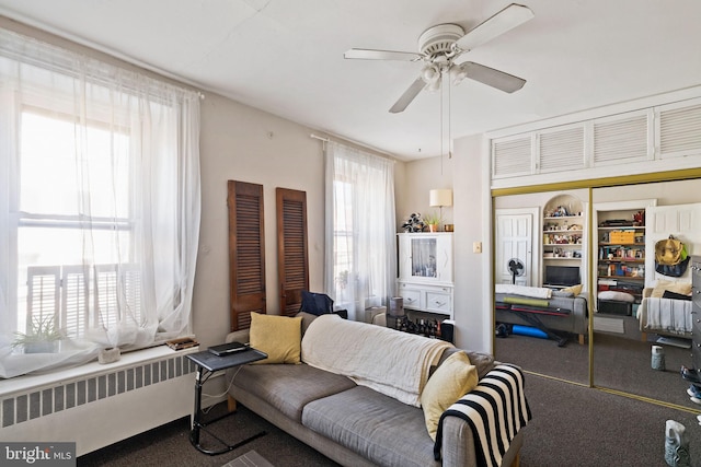 living room featuring carpet floors, radiator heating unit, and ceiling fan