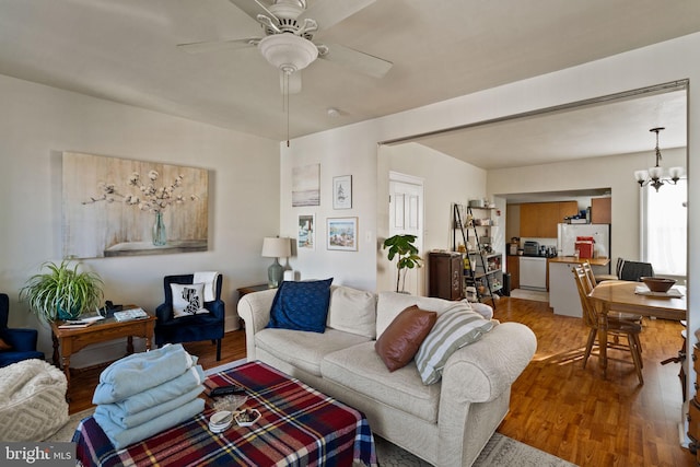 living room featuring hardwood / wood-style flooring and ceiling fan with notable chandelier