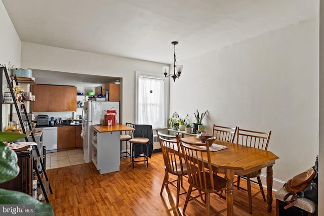 dining space featuring a chandelier and light wood-type flooring