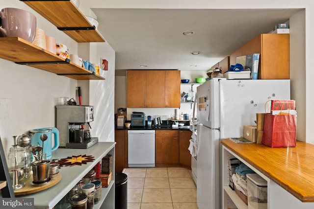 kitchen featuring light tile patterned flooring and white appliances