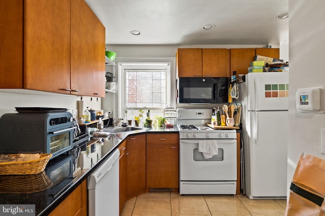 kitchen with sink, white appliances, and light tile patterned flooring