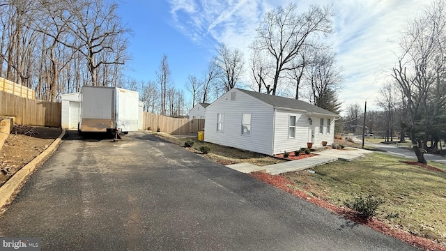 view of property exterior with an outbuilding and a lawn