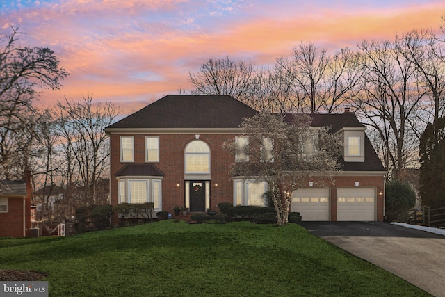 view of front of property featuring a garage and a lawn