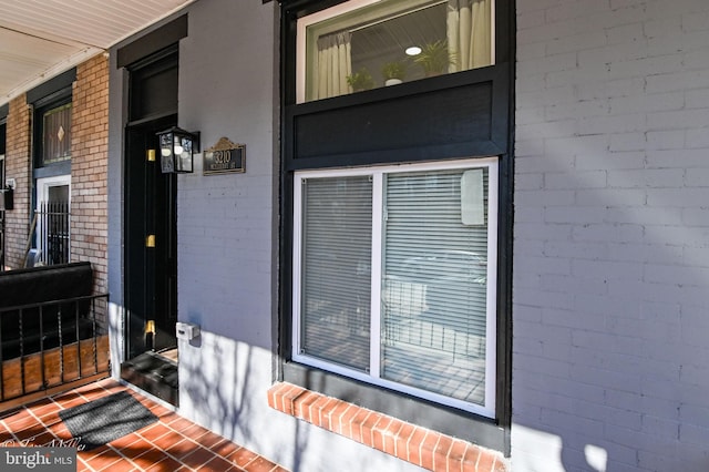 property entrance featuring brick siding