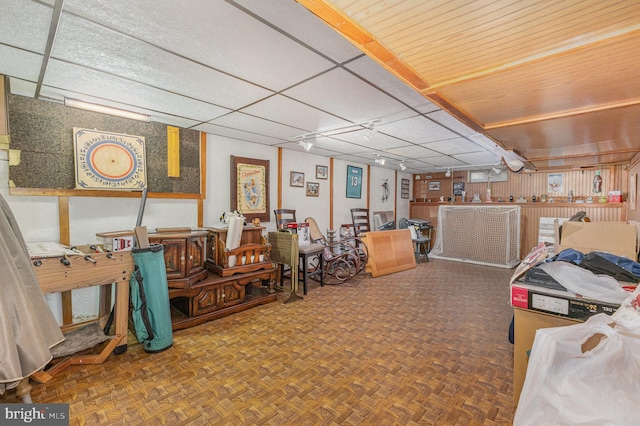 misc room featuring parquet floors and a paneled ceiling