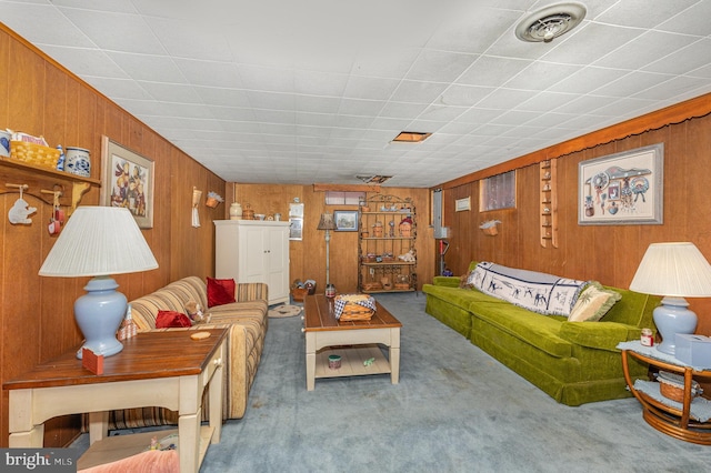 carpeted living room featuring wood walls