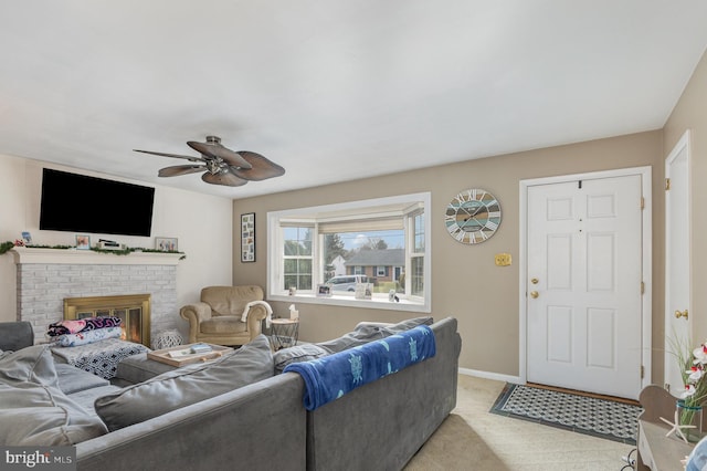 carpeted living room with a brick fireplace and ceiling fan