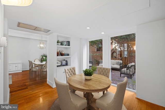 dining space featuring wood-type flooring and built in features