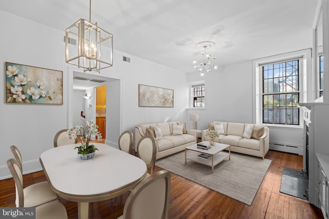 living room featuring hardwood / wood-style flooring, a chandelier, and baseboard heating