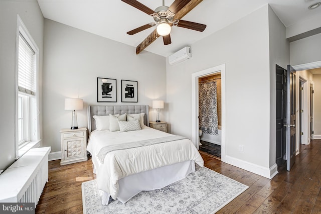 bedroom featuring baseboards, a ceiling fan, dark wood-style floors, ensuite bath, and an AC wall unit