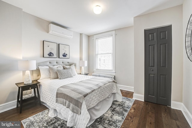 bedroom with radiator, a wall unit AC, baseboards, and dark wood-style flooring