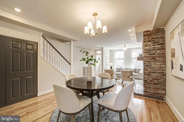 dining area with a chandelier, light wood-style flooring, recessed lighting, baseboards, and stairway