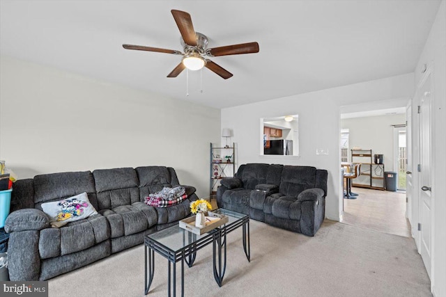 carpeted living room with ceiling fan