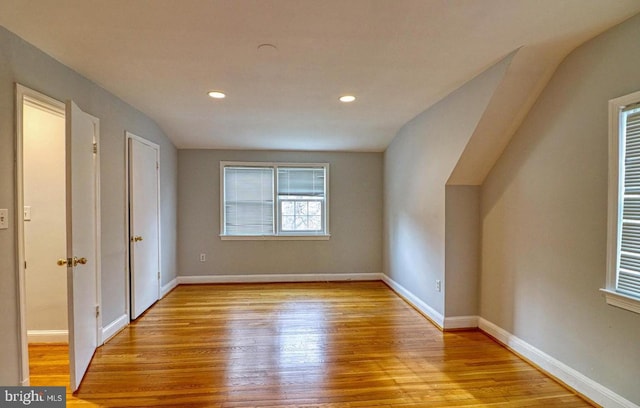 bonus room with lofted ceiling and light hardwood / wood-style floors