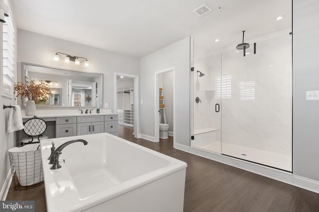 bathroom with vanity, hardwood / wood-style floors, and plus walk in shower