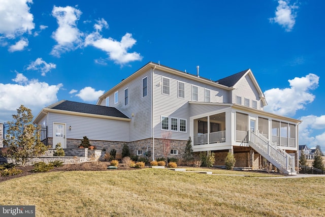 back of property with a sunroom and a lawn