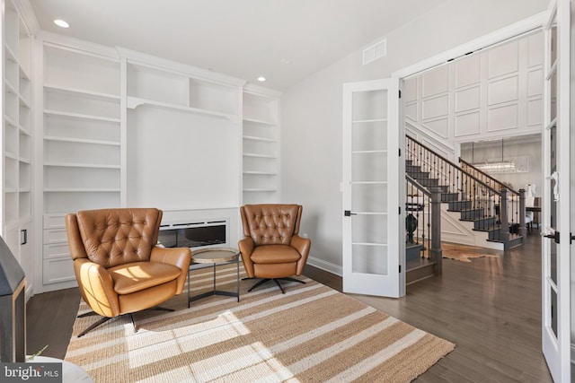 sitting room featuring vaulted ceiling, dark hardwood / wood-style floors, built in features, and french doors