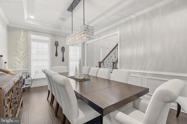 dining room with crown molding, dark wood-type flooring, and a tray ceiling