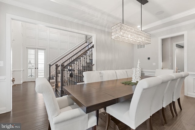 dining space featuring ornamental molding, a chandelier, and dark hardwood / wood-style flooring