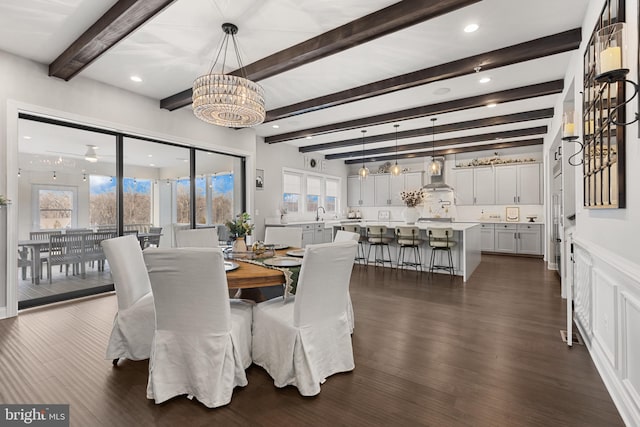 dining room featuring dark wood-type flooring, beamed ceiling, and a chandelier