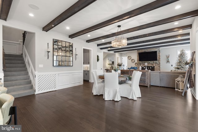 dining room featuring dark hardwood / wood-style flooring, beam ceiling, and an inviting chandelier