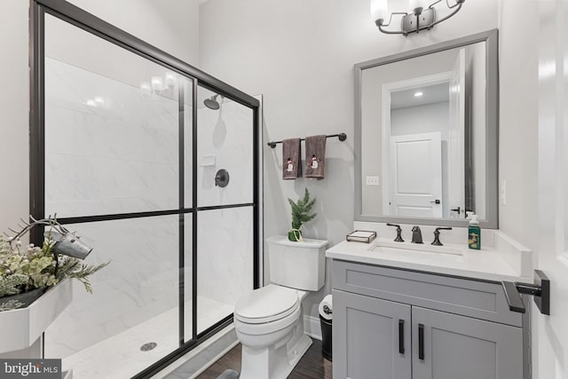 bathroom featuring vanity, toilet, a shower with shower door, and hardwood / wood-style floors