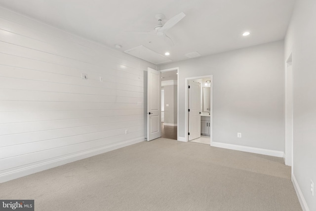 unfurnished bedroom featuring ceiling fan, light colored carpet, and ensuite bathroom