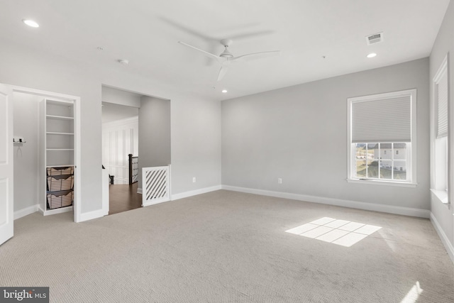 unfurnished room with light colored carpet and ceiling fan