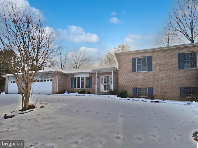 view of front of property with central AC unit, brick siding, and an attached garage