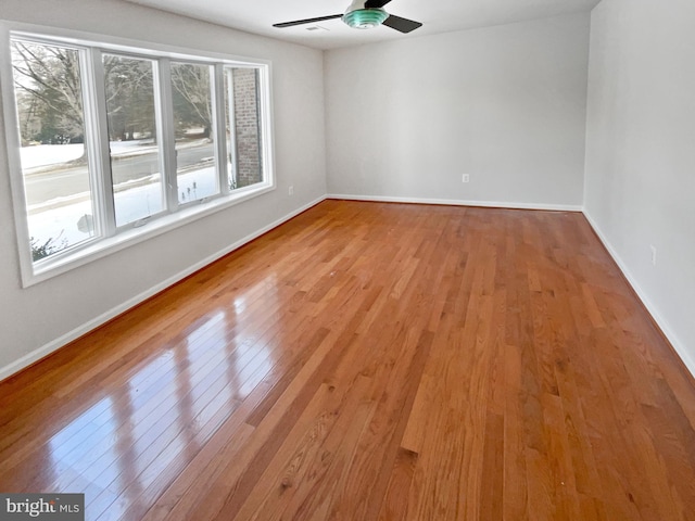 unfurnished room with ceiling fan, plenty of natural light, light wood-style flooring, and baseboards