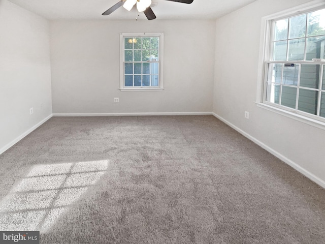 carpeted empty room featuring a ceiling fan and baseboards