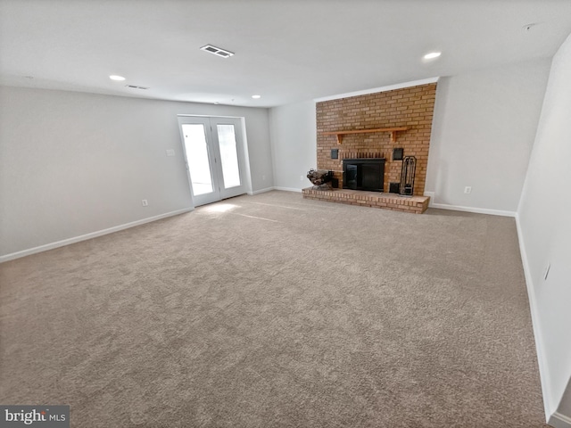 unfurnished living room featuring carpet, recessed lighting, visible vents, a brick fireplace, and baseboards