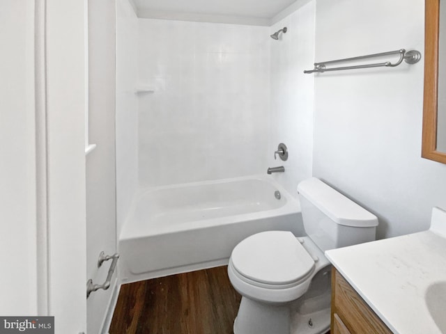 full bathroom with washtub / shower combination, vanity, wood finished floors, and toilet