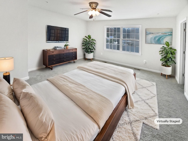 carpeted bedroom with ceiling fan and baseboards