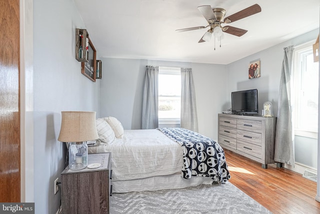 bedroom with light wood-type flooring, visible vents, and a ceiling fan