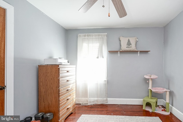 bedroom featuring baseboards, dark wood finished floors, and a ceiling fan