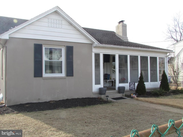 view of front facade with a front lawn and a sunroom